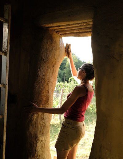 Sármíves képzésen a fecskefészek otthonomnál lány vályog tapasztást csinál